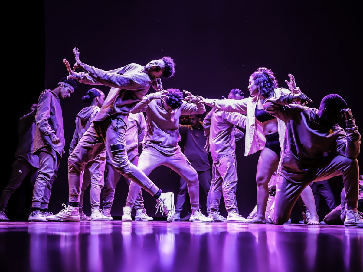 Grupo K-pop em atuação no palco — coreografia preparada, energia pop e público a acompanhar.